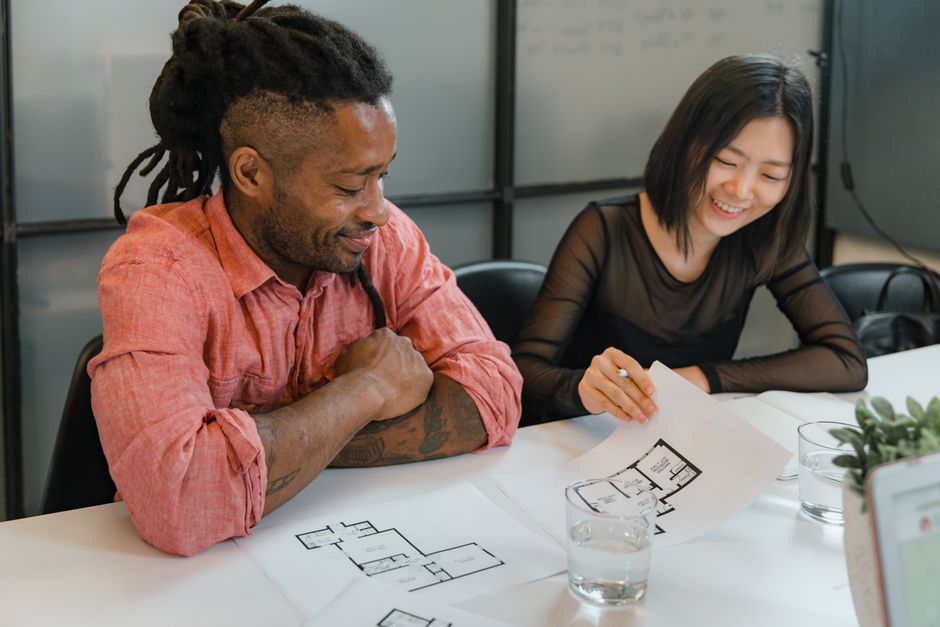 A diverse team of professionals collaborating on architectural plans, promoting teamwork and creativity.